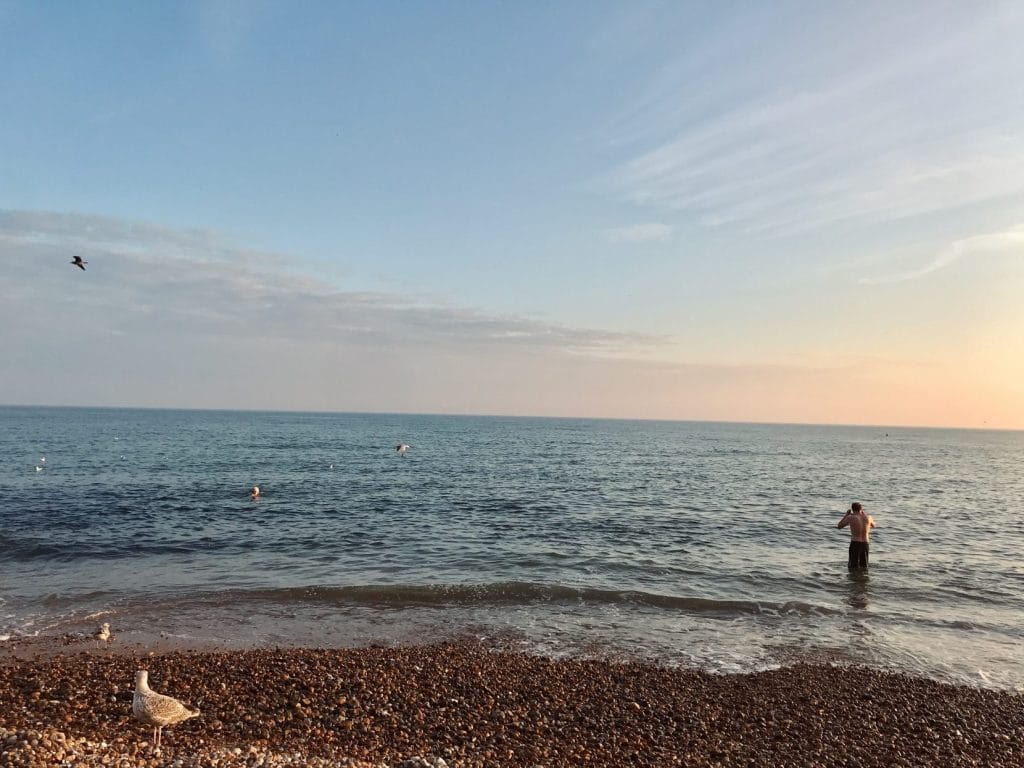 Man paddling in the sea at brighton beach.