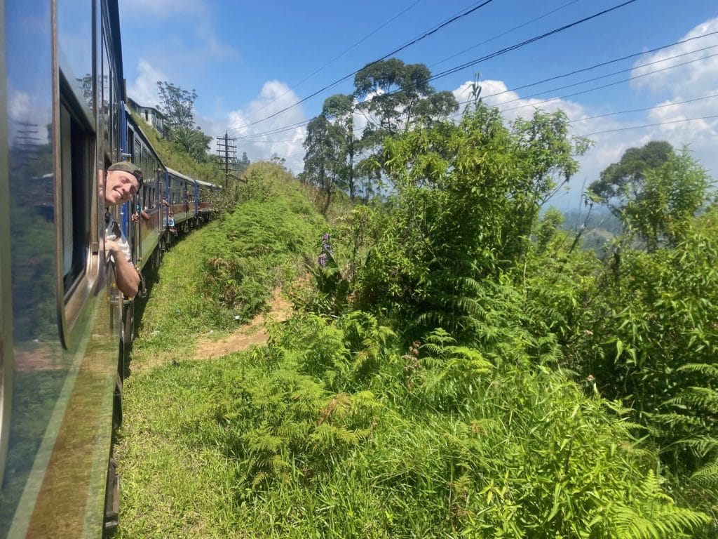 Man leans out of train window.