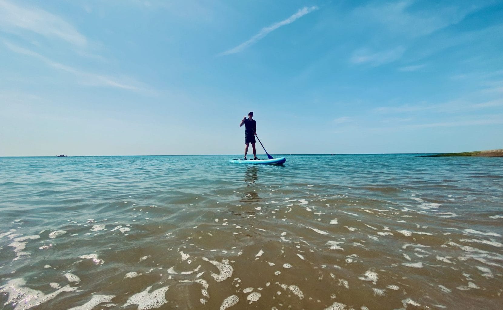 Man paddleboarding in the sea at brighton beach.