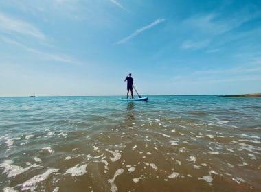 Man paddleboarding in the sea at Brighton beach.