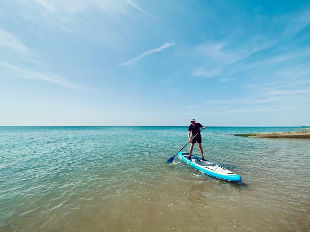 Man uses paddleboards in brighton.