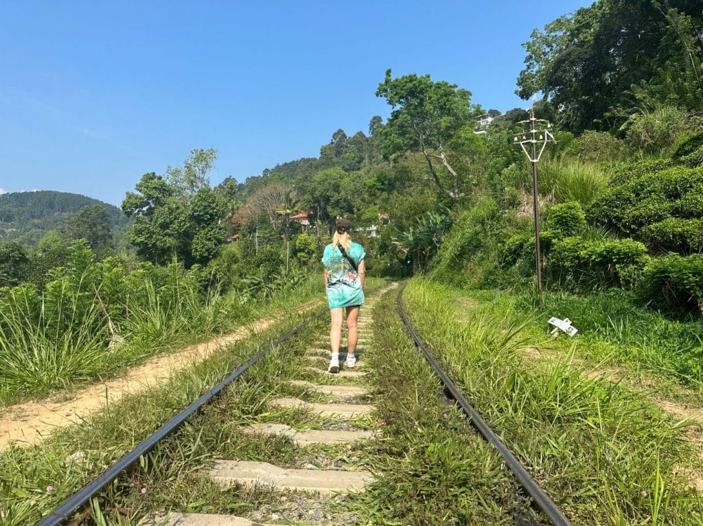 Person walks along train tracks in sri lanka.