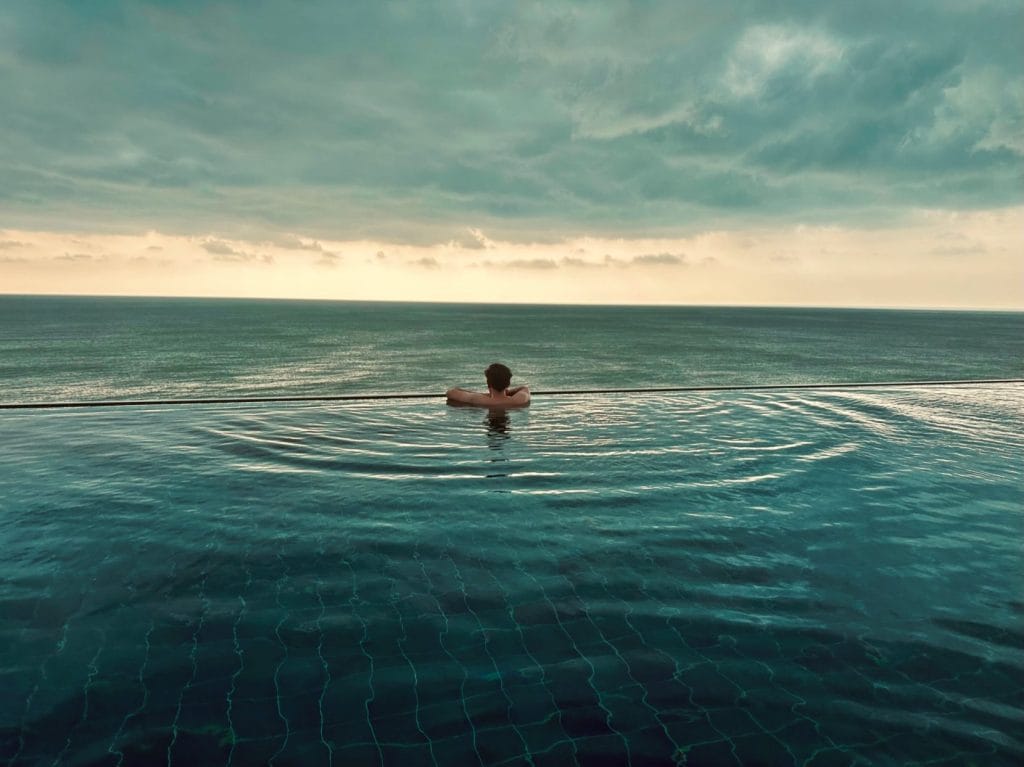 Man swimming in rooftop pool.