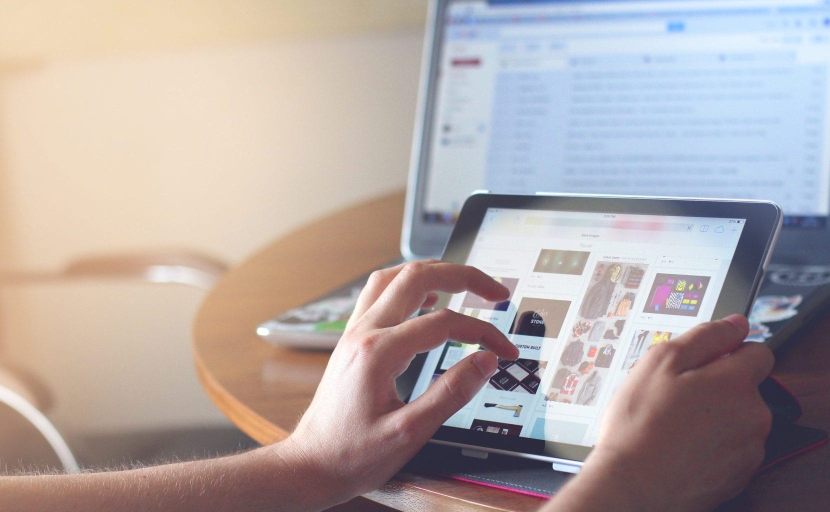 Person using ipad and macbook.