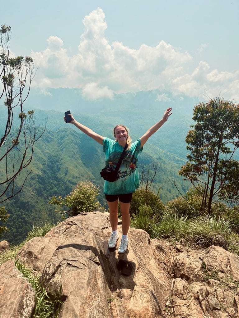 Woman smiles at top of hill.