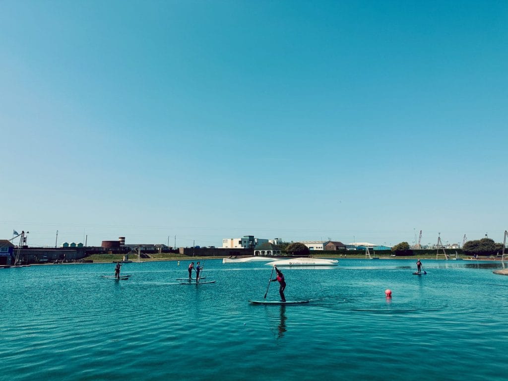 People paddleboarding on hove lagoon, brighton.